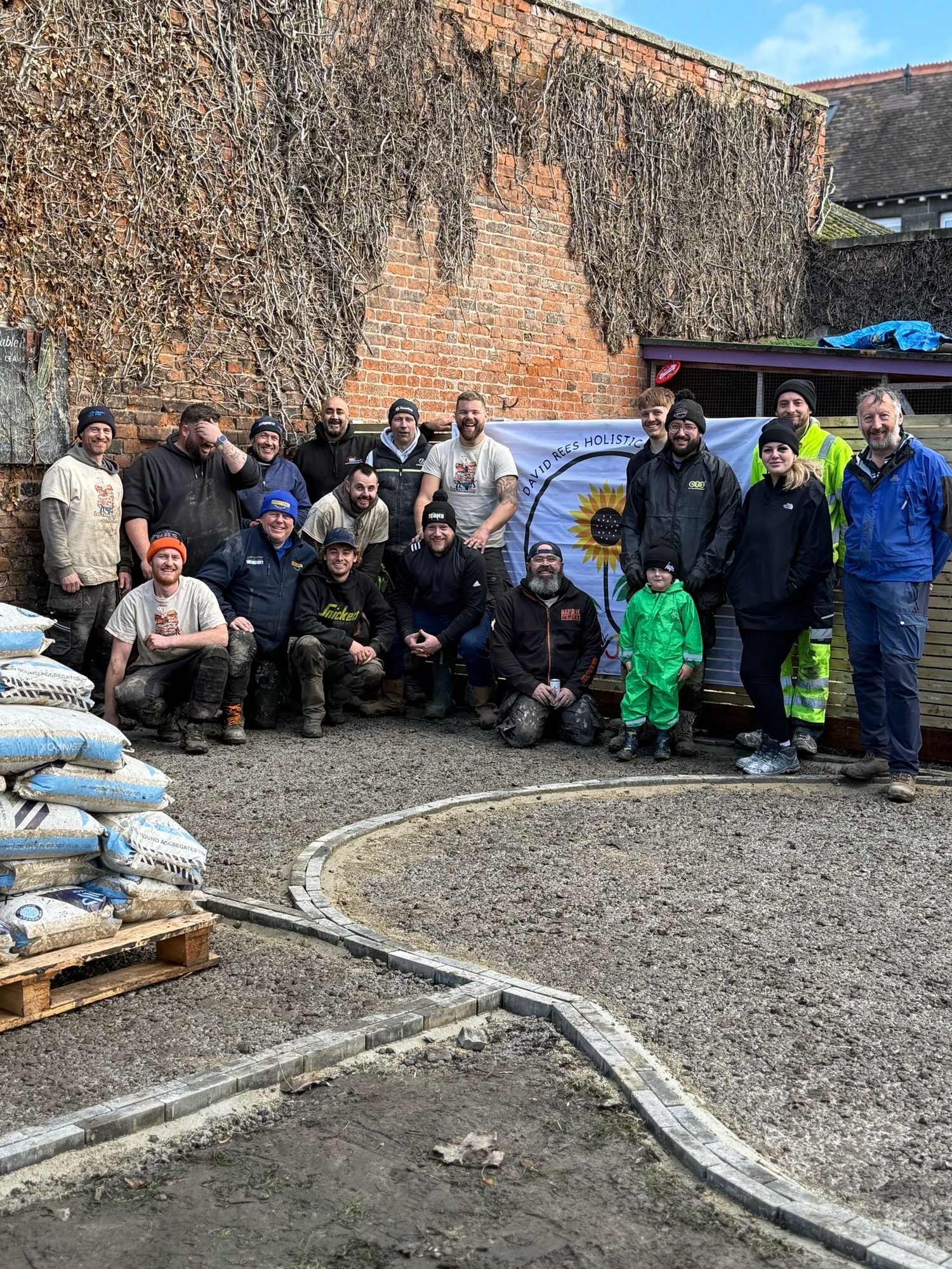 The Gardenscape crew and volunteer tradespeople on the build day in front of the charity banner
