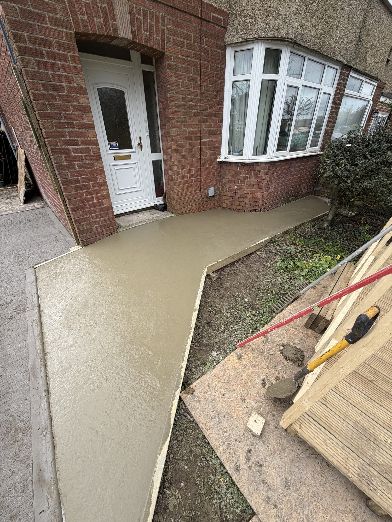 Freshly poured concrete base at a house frontage during works