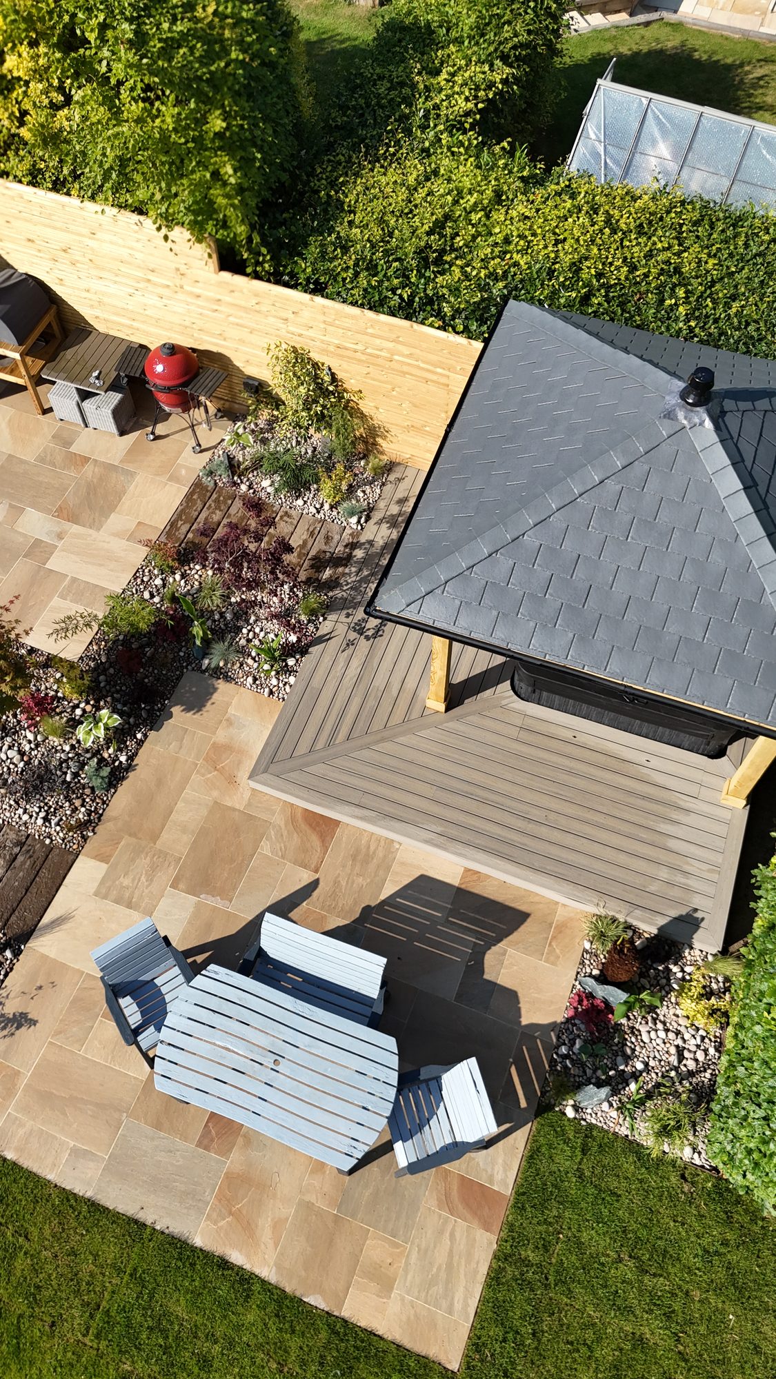 Top-down view of a sandstone patio and lawn